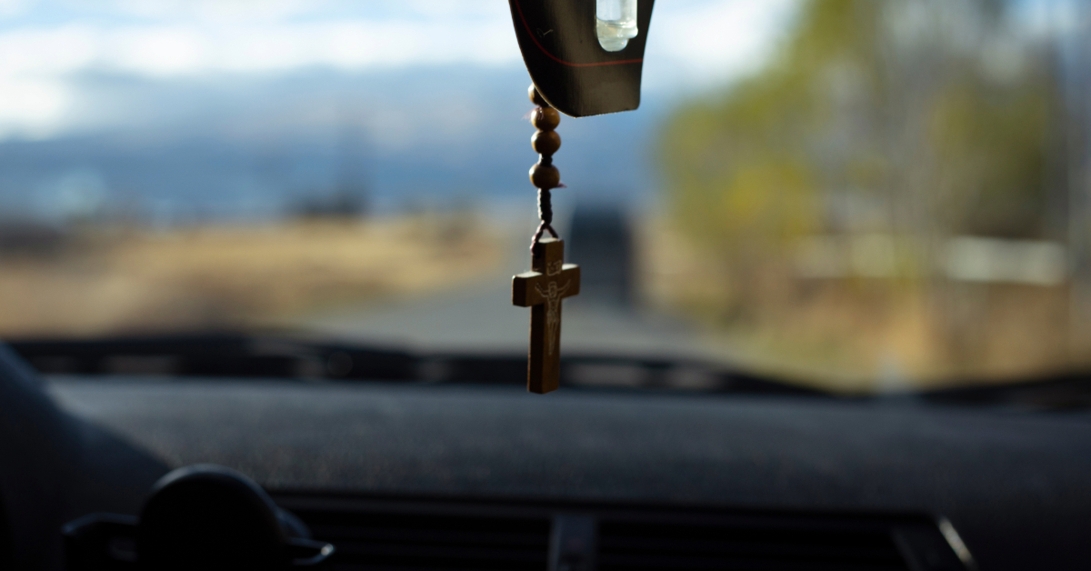 Driver from a Christian trucking company driving with a Crucifix hanging on the rear view mirror